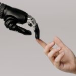 Digitale zelfhulp symbolisch uitgebeeld door een robotische hand die een menselijke vinger aanraakt.